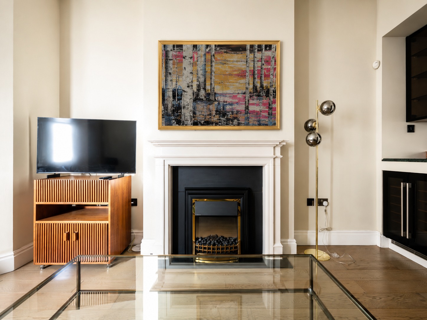 A gold-framed painting above a fireplace