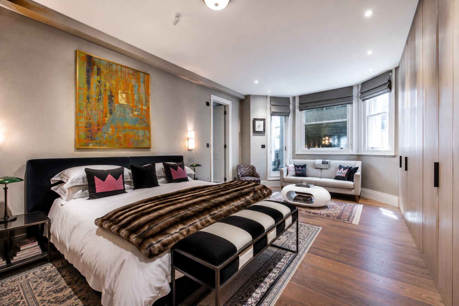 A gold-framed painting above a bed in a principal bedroom