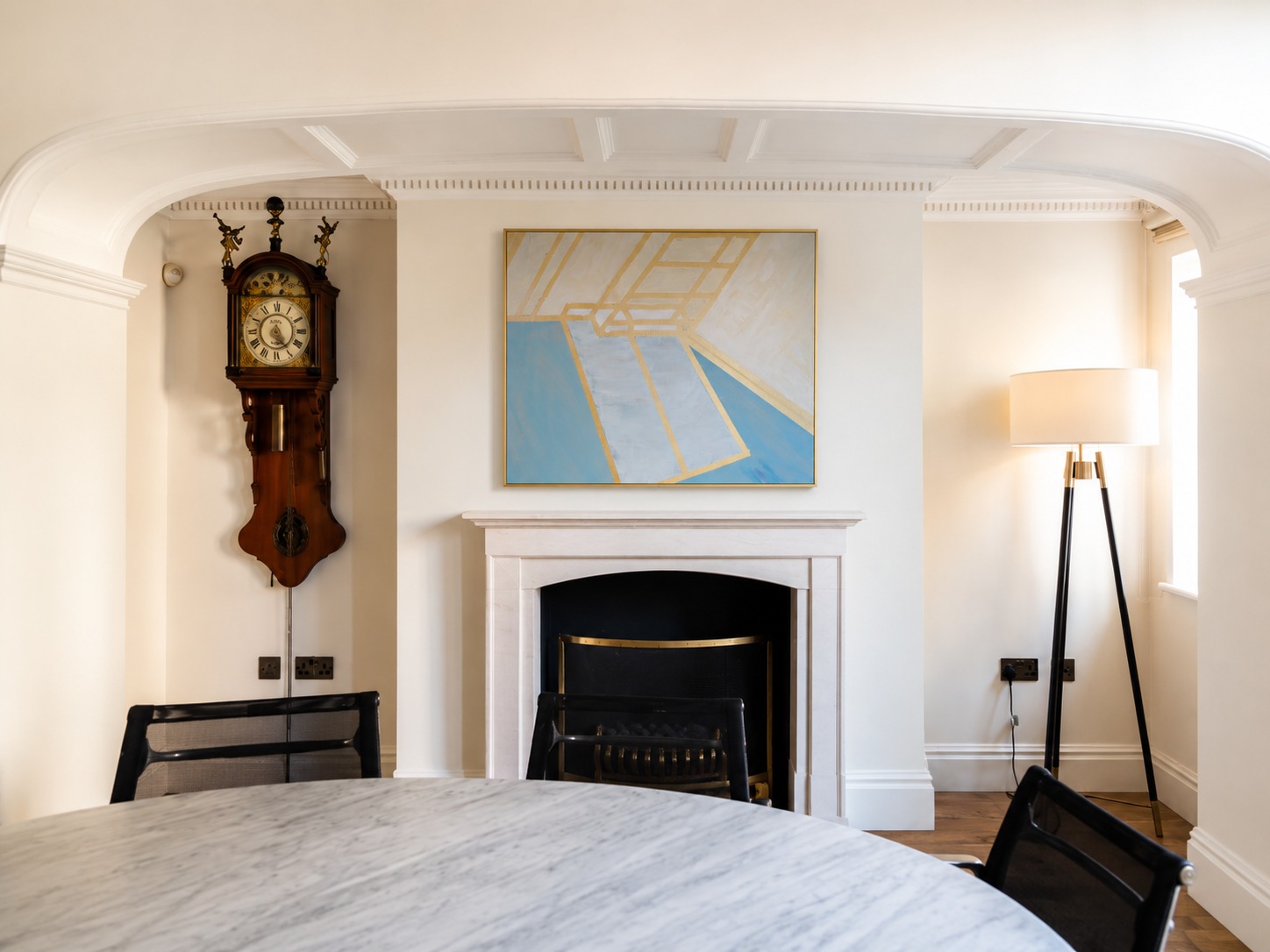 A blue and gold geometric painting in a dining room
