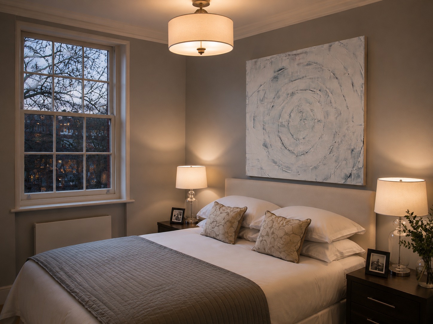 A pale circular painting above a bed