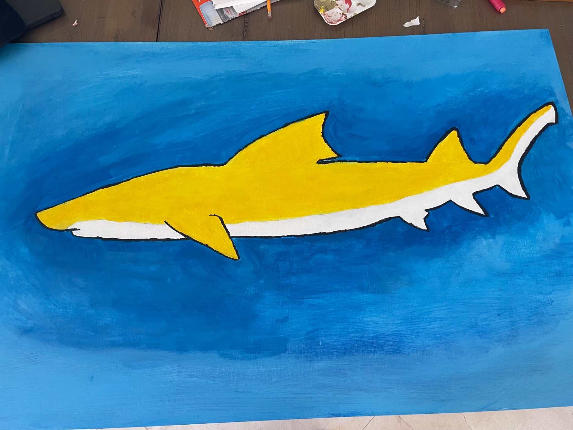 Finished painting of a yellow shark on a blue ground