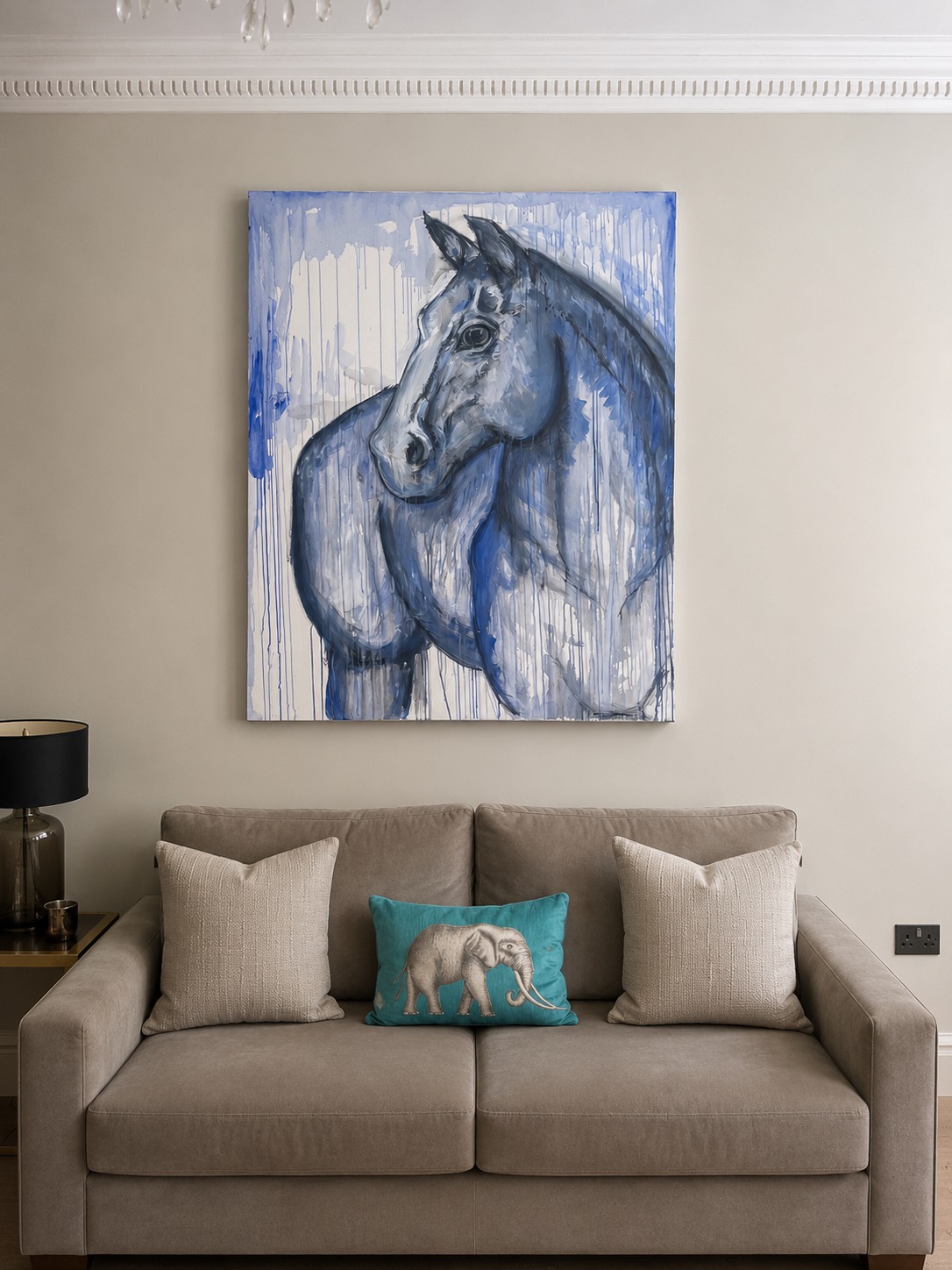 A blue horse painting above a sofa