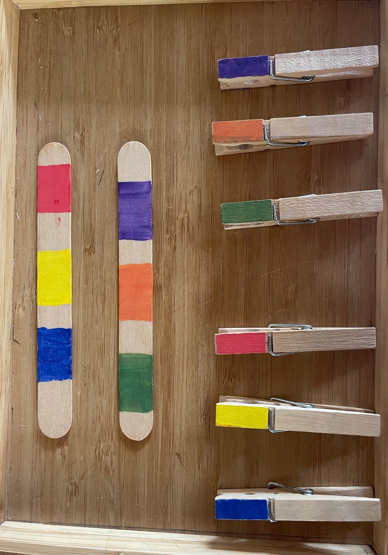 Painted lolly sticks and pegs for a colour-matching activity